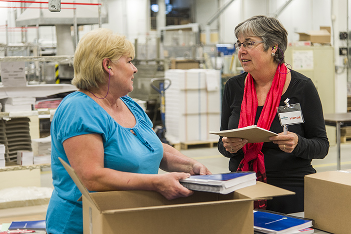 Heart Institute vocational counsellor Laura Cupper (right) often travels to work sites to assess job-related demands that could pose problems for heart disease patients. Here she observes bindery worker Maureen Lafontaine at a printing facility of the Lowe-Martin Group. 