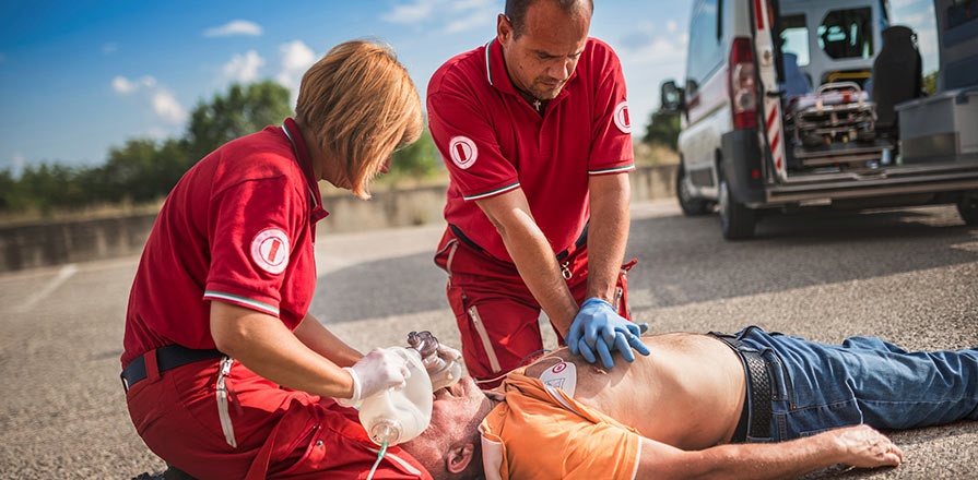 Deux ambulanciers tentent de réanimer une victime d'arrêt cardiaque